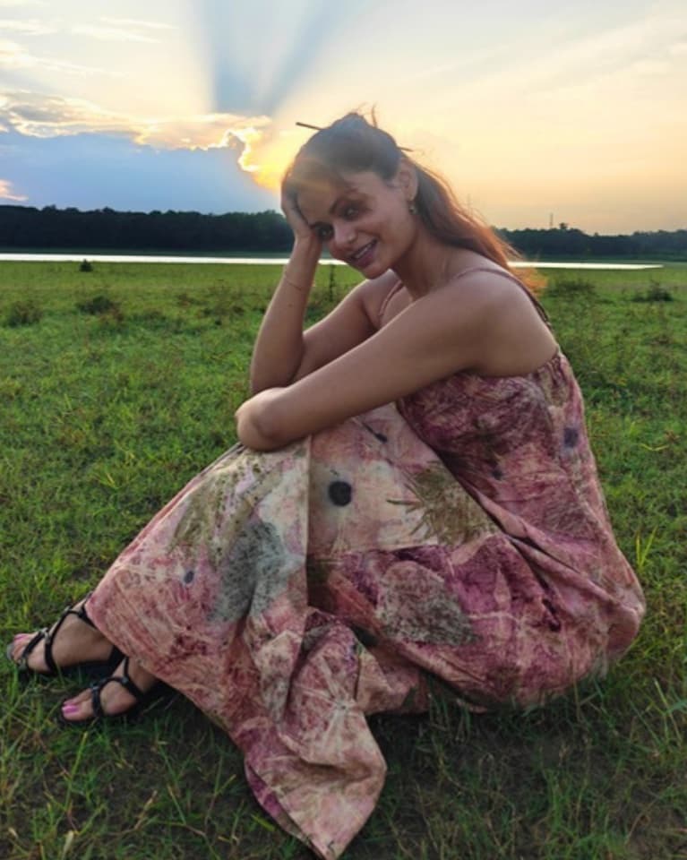 Sama’s founder sitting in a meadow at sunset